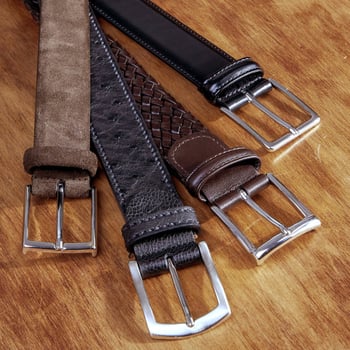 Guide Essential Belts. A picture of three woven leather belts from Andersons: one braided brown belt, one black plain leather belt and one suede belt. The fourth belt is a ostrich belt from Canali.